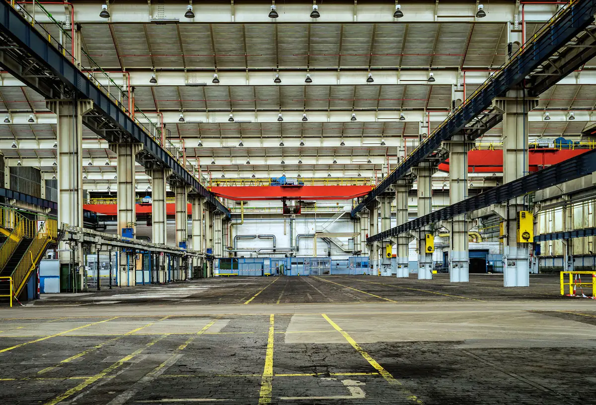 Interior amplo de galpão industrial com pilares, vigas metálicas e cobertura